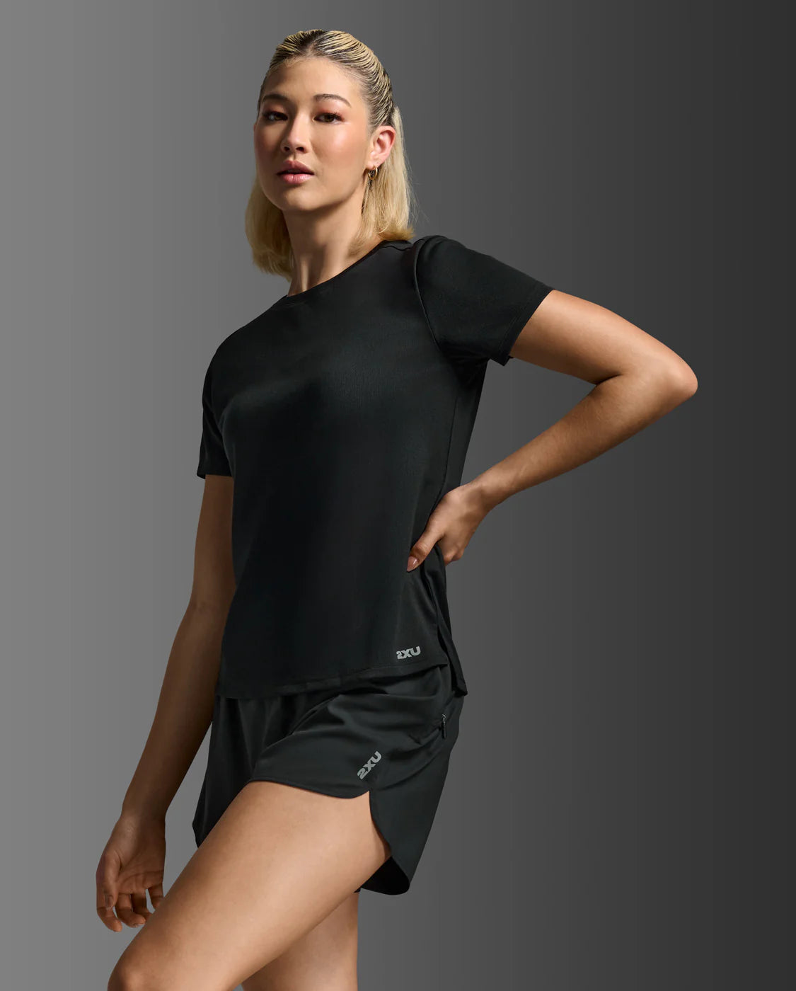 Woman wearing a black athletic outfit on a gray background