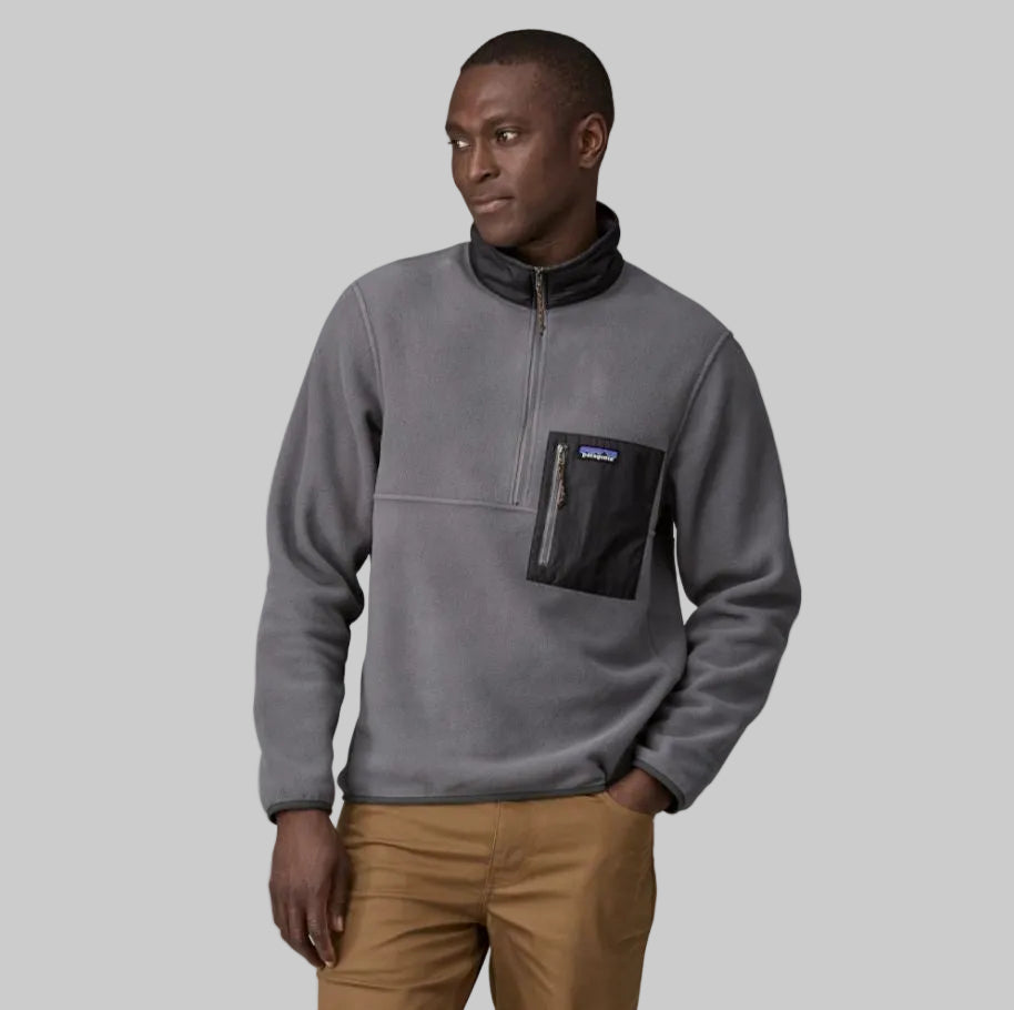 A man wearing a gray Patagonia Micro D half-zip fleece pullover with a front pocket, paired with beige pants.
