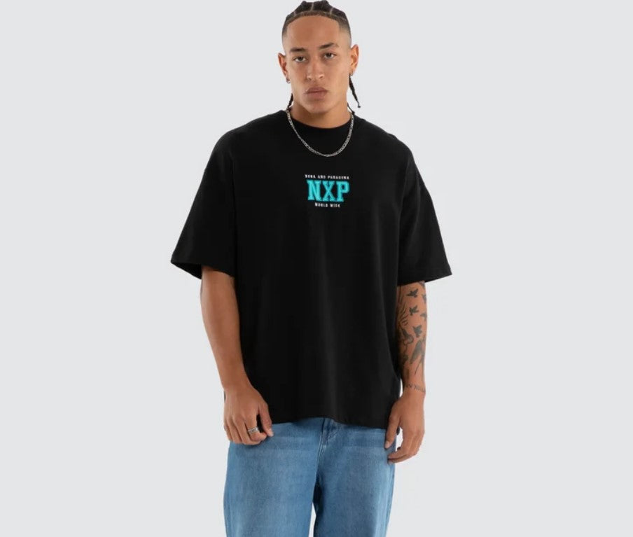 A person shown from the back wearing a black oversized T-shirt with a large turquoise and white graphic reading 'NENA AND PASADENA Upscale Supply WORLD WIDE MISSION' on a light gray studio background. WEST LOOPBACK RAPTOR TEE ANTHRACITE