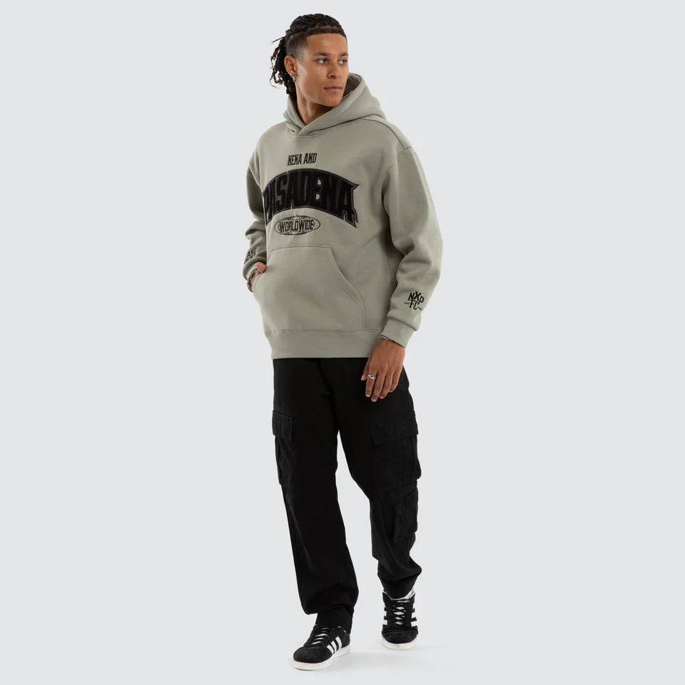 Person wearing a gray hoodie with text and black pants on a white background