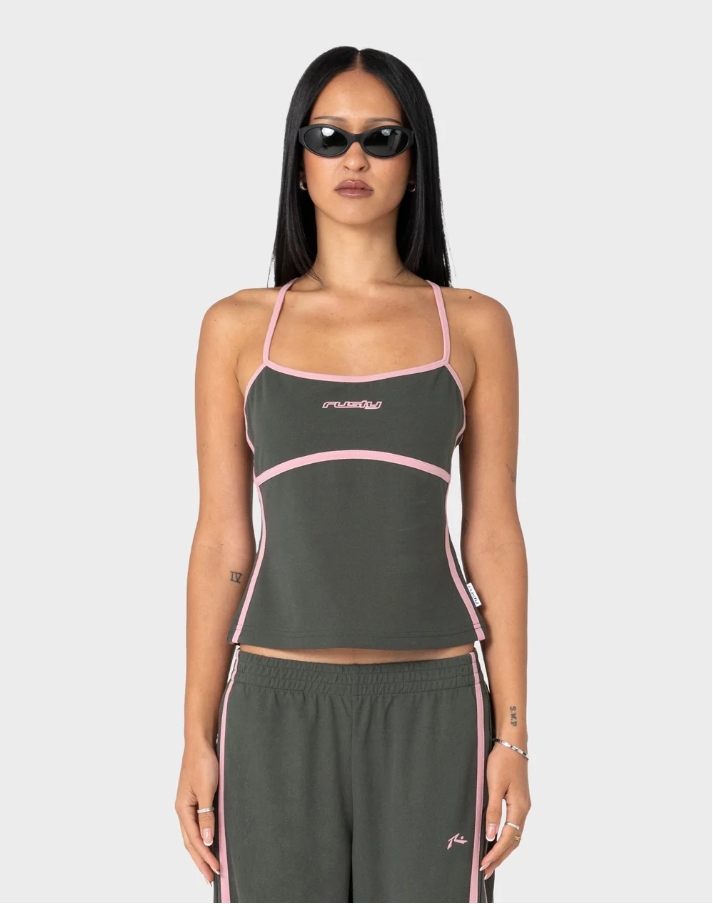 A model wearing a dark olive green two-piece activewear set with pink trim, consisting of a cropped tank top and matching sweatpants, set against a plain light gray background. FREO KING FITTED TOP SAVANNA GREEN PINK LADIES TANK SINGLET TOP RUSTY