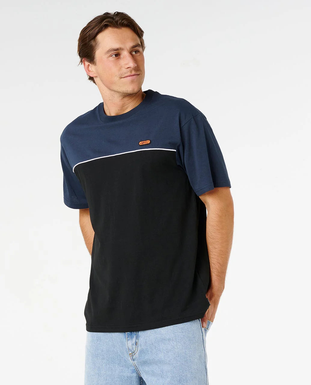 Man wearing a navy and black t-shirt with a logo on a white background