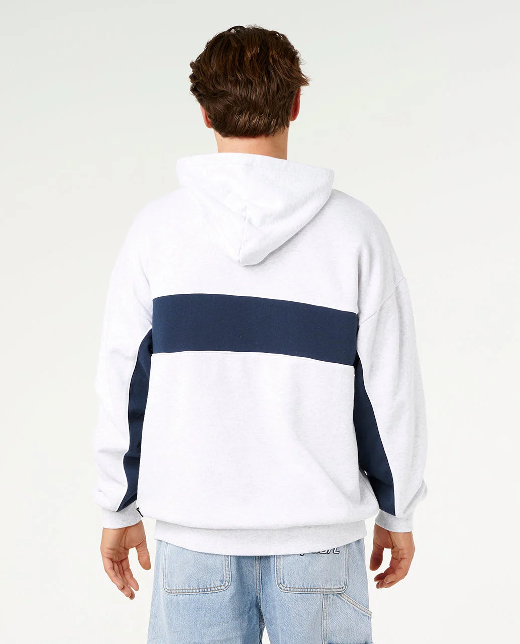 Person wearing a white hoodie with a navy stripe on a plain background