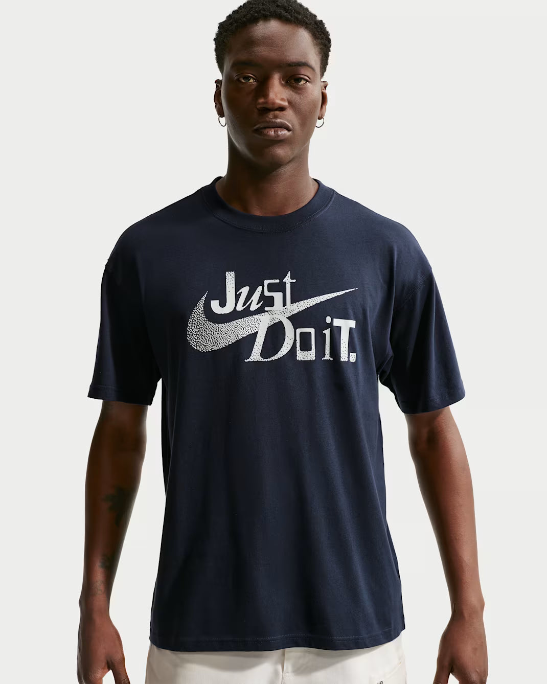 Person wearing a navy blue t-shirt with 'Just Do It' logo on a white background