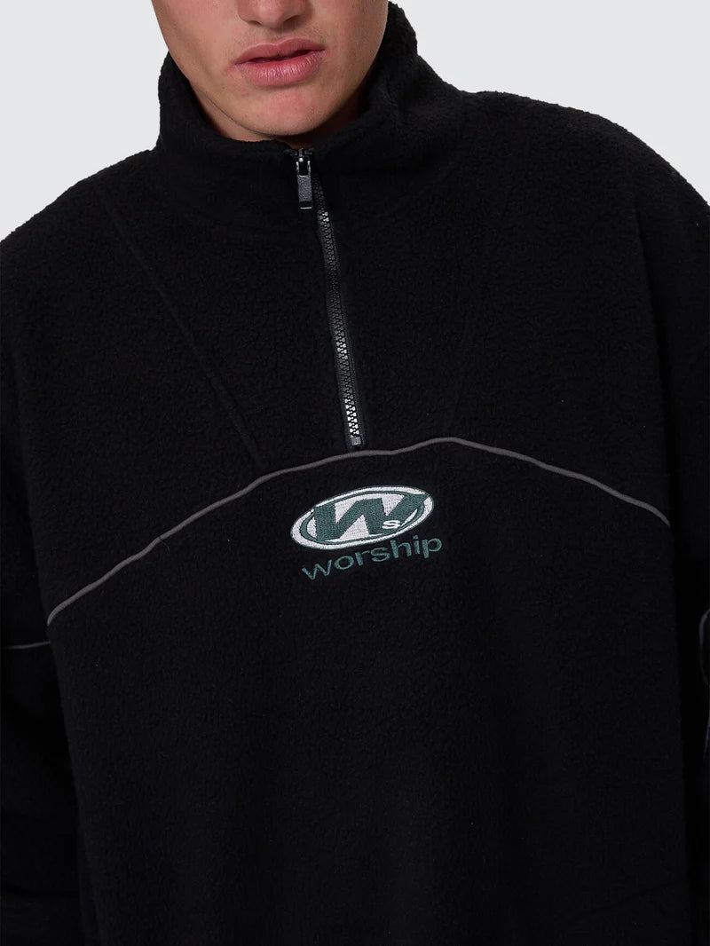 Black fleece pullover with 'Worship' logo on a gray background