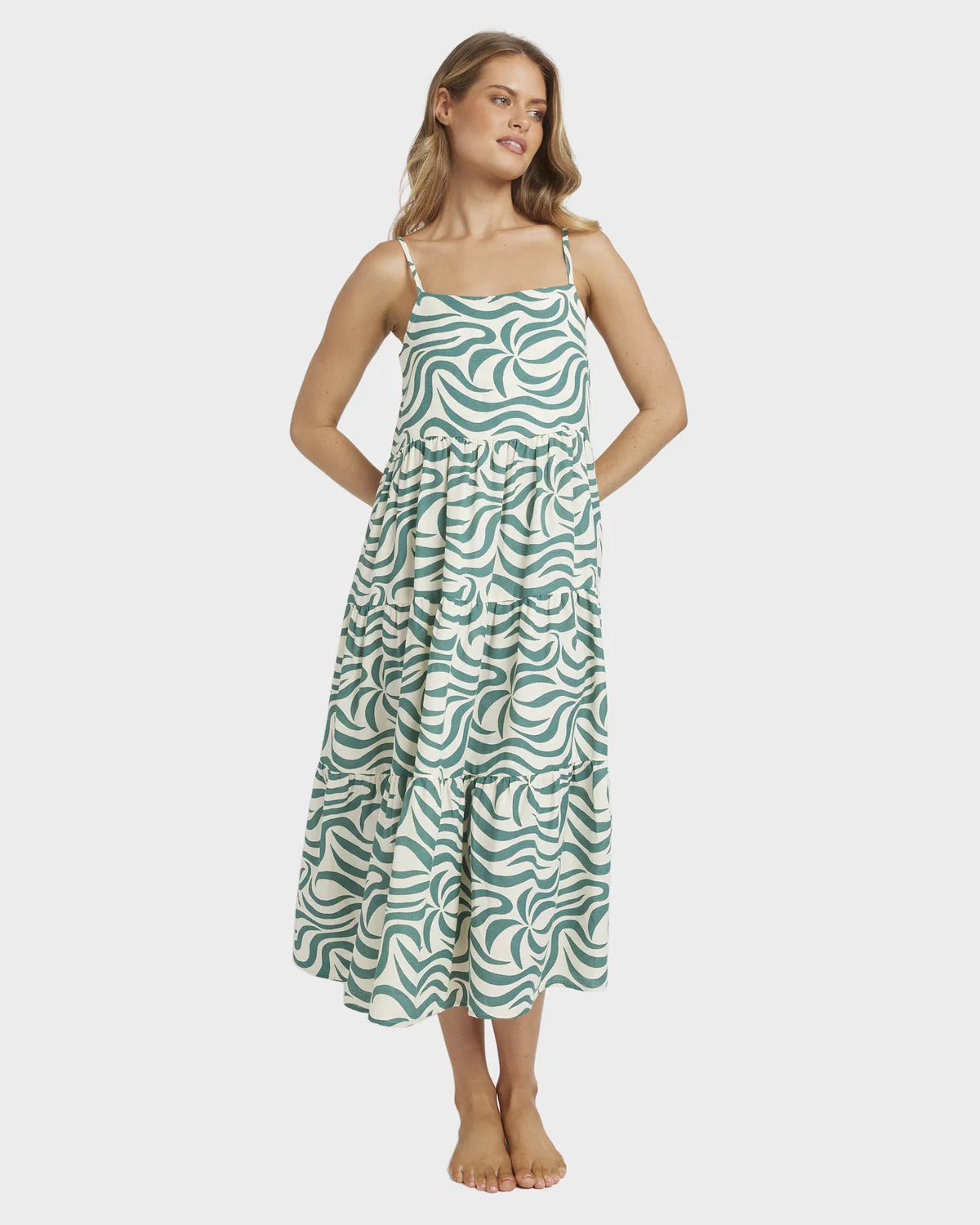 Woman wearing a green patterned dress on a white background