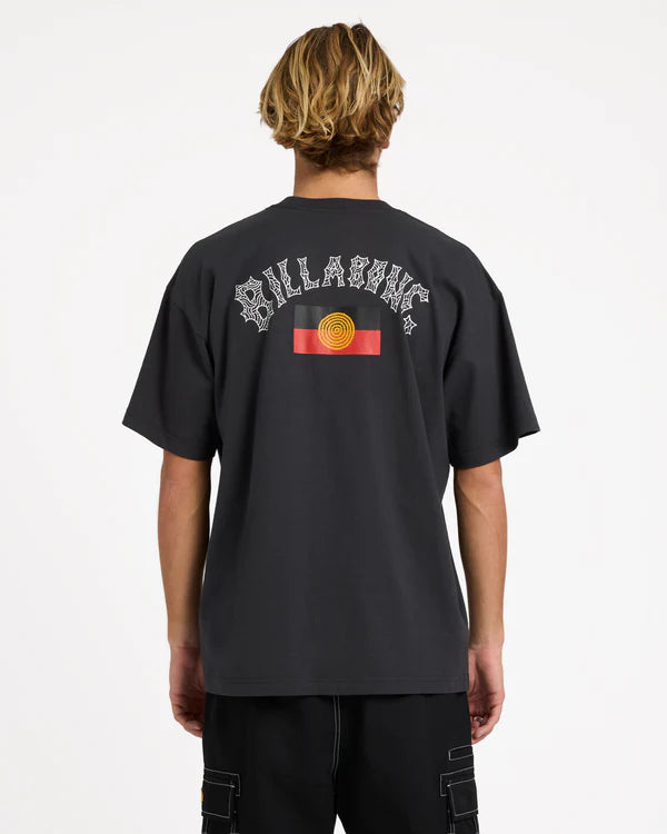 Person wearing a black t-shirt with 'Billabong' logo on the back, standing against a white background