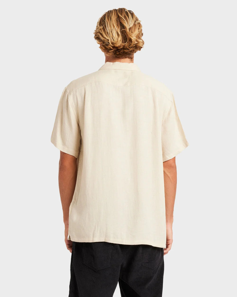 Person wearing a beige short-sleeve shirt on a white background