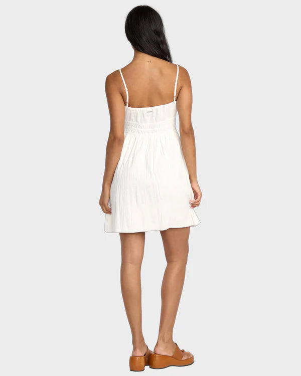 Woman wearing a white dress on a plain background