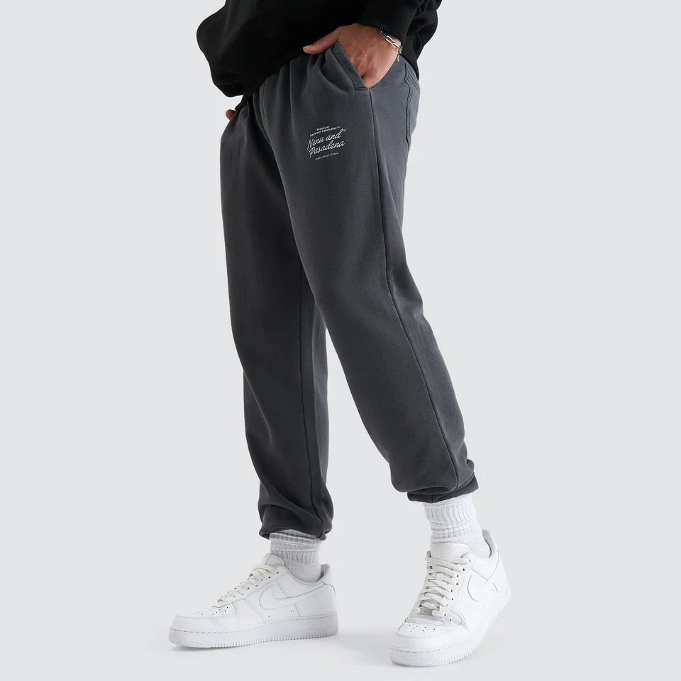 Person wearing dark gray sweatpants with a logo on a white background
