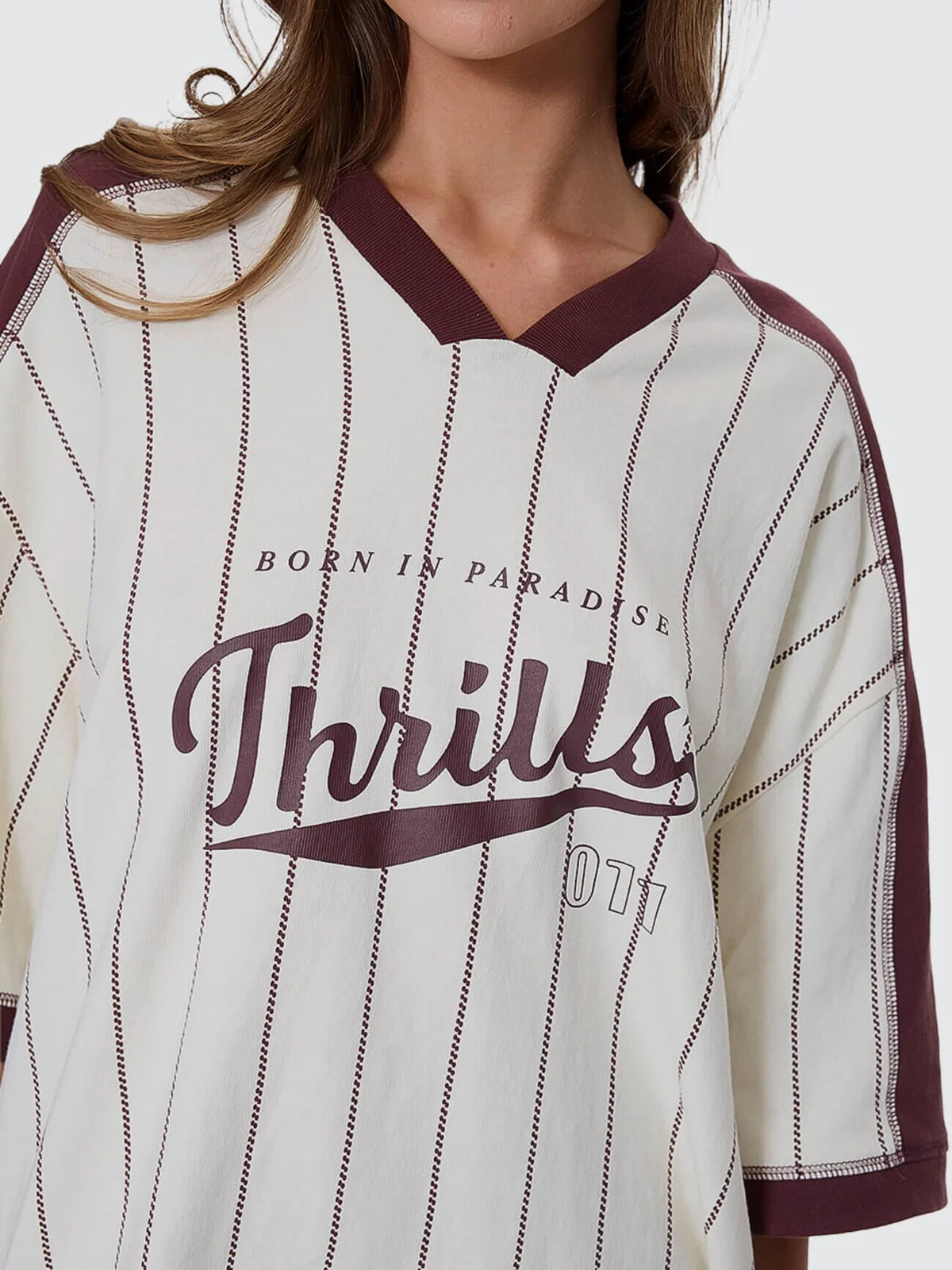 Baseball-style jersey with 'Born in Paradise Thrills' text on a white background