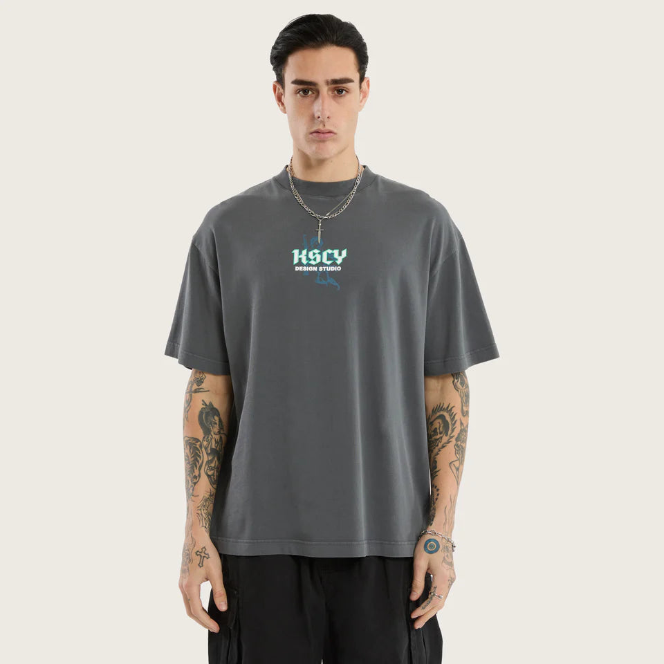 Person wearing a gray t-shirt with a logo on a plain background