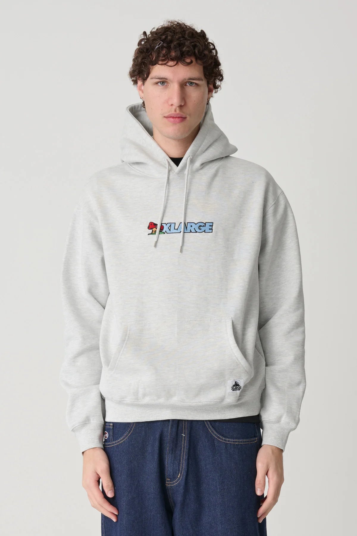 Person wearing a gray hoodie with an XLarge logo on a plain background