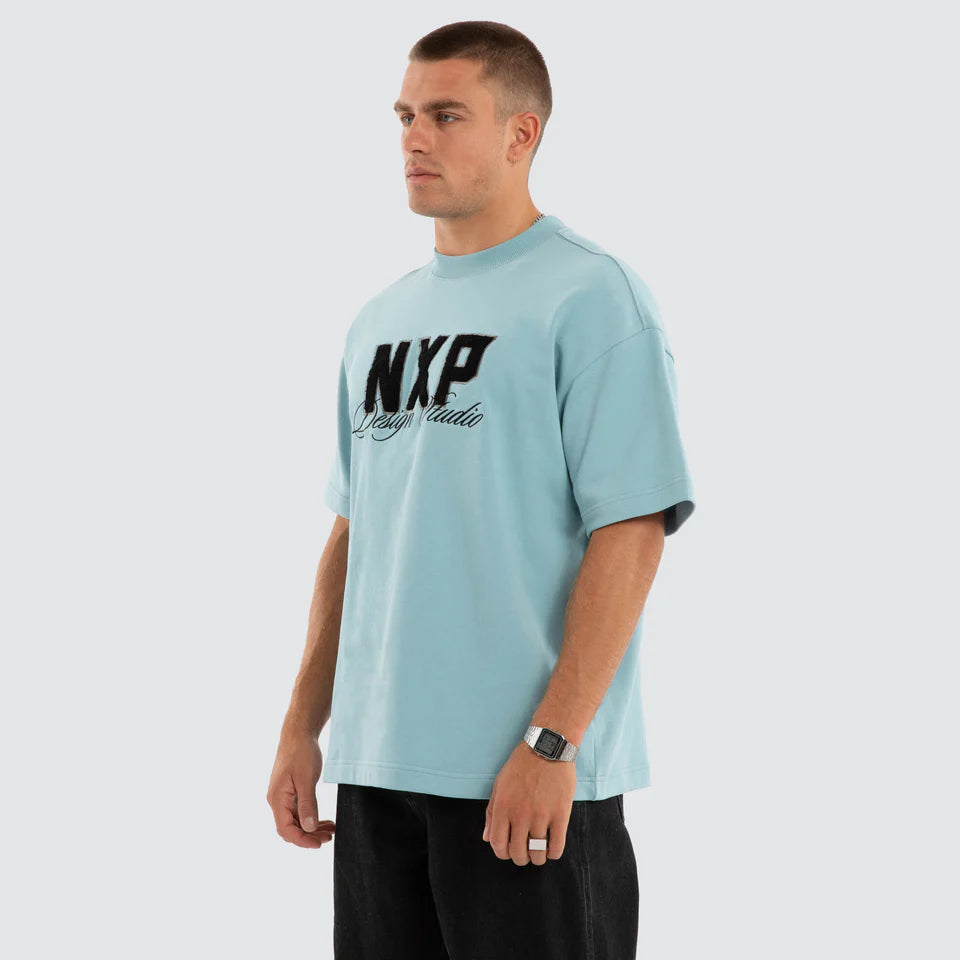 Man wearing a light blue t-shirt with 'NXP' logo on a white background