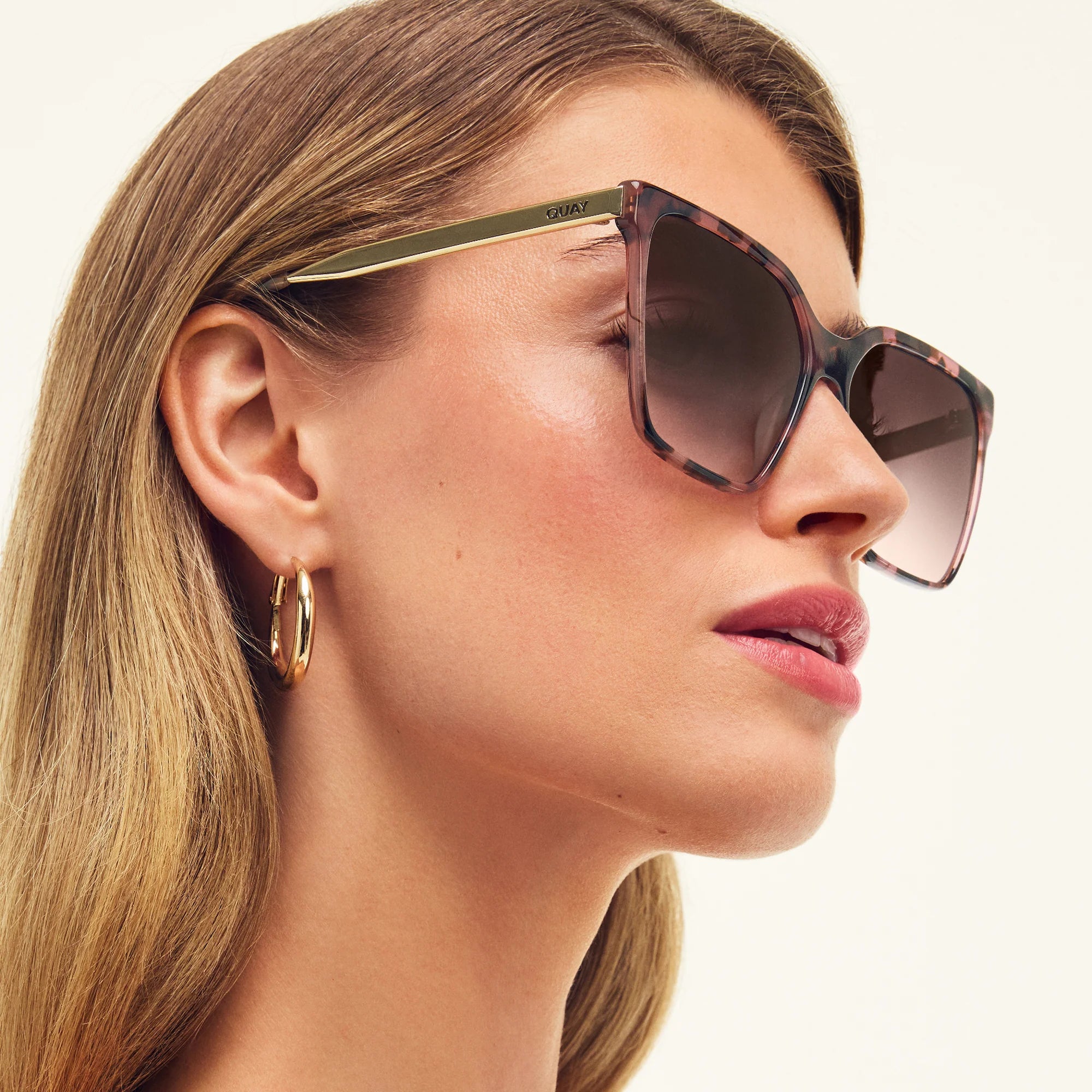 Woman wearing sunglasses with a neutral background
