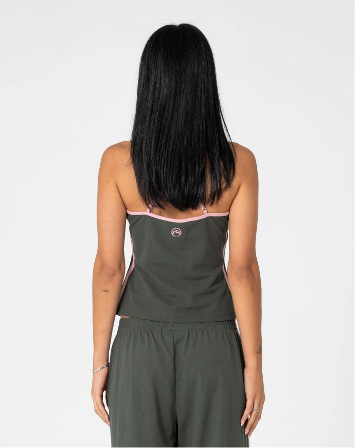 A model wearing a dark olive green two-piece activewear set with pink trim, consisting of a cropped tank top and matching sweatpants, set against a plain light gray background. FREO KING FITTED TOP SAVANNA GREEN PINK LADIES TANK SINGLET TOP RUSTY