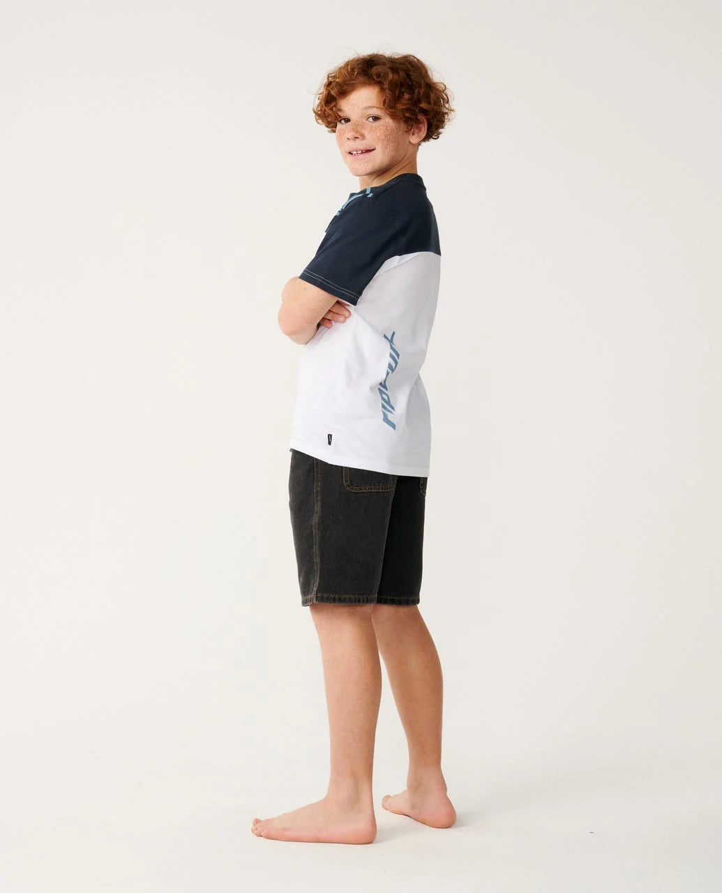 Child wearing a two-tone shirt and shorts on a white background