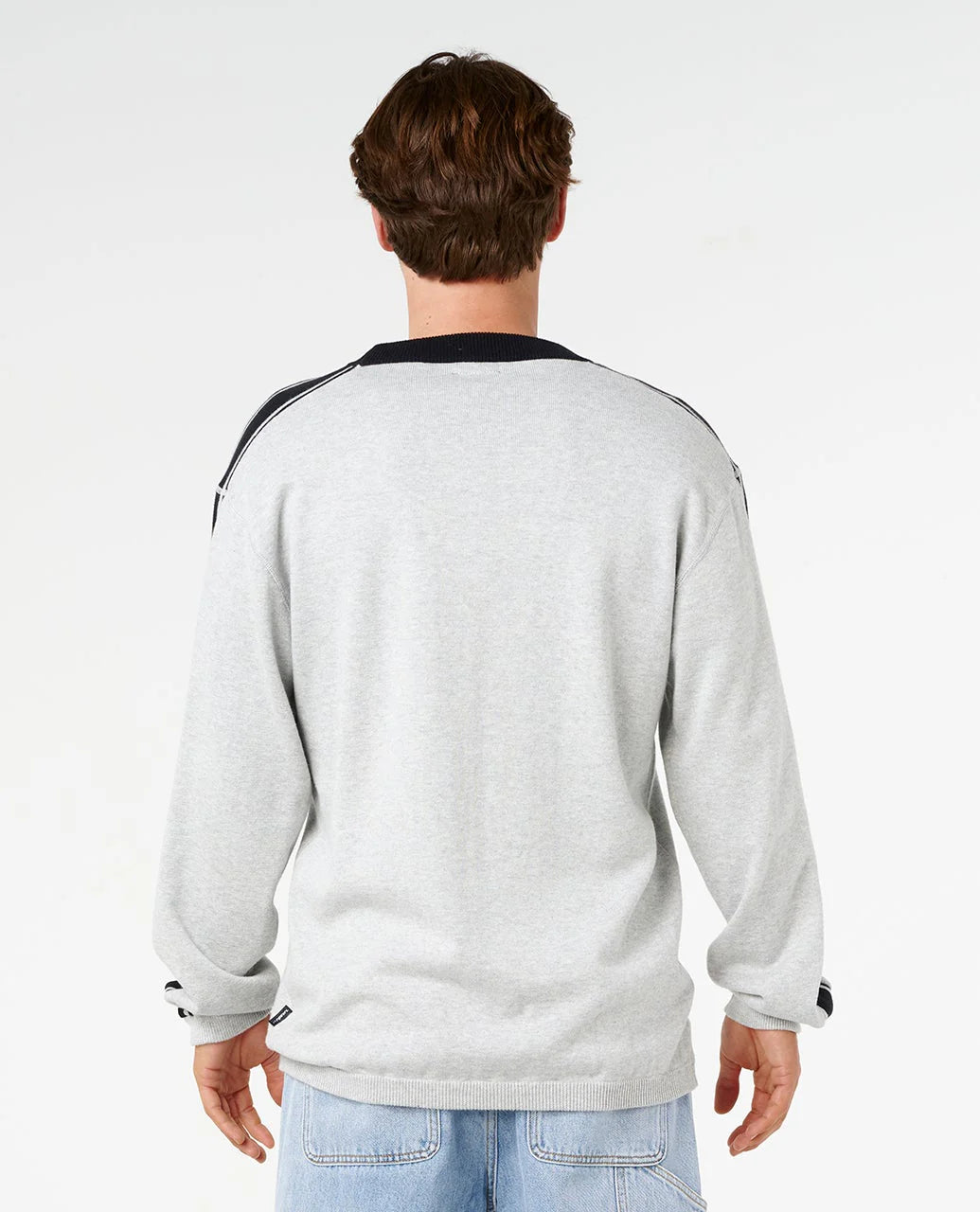 Person wearing a light gray sweatshirt with black accents on a white background