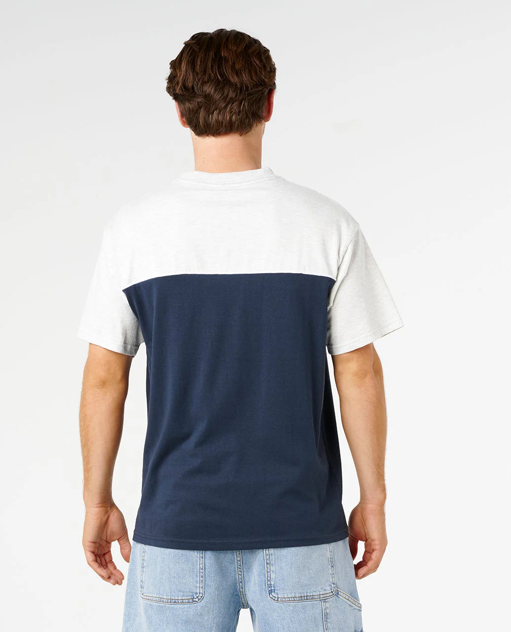 Person wearing a two-tone t-shirt with white sleeves and navy body on a plain background