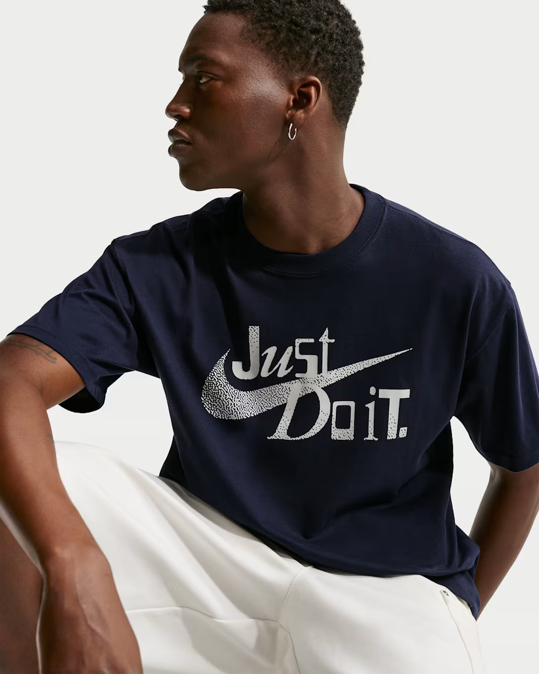 Person wearing a navy blue t-shirt with 'Just Do It' logo