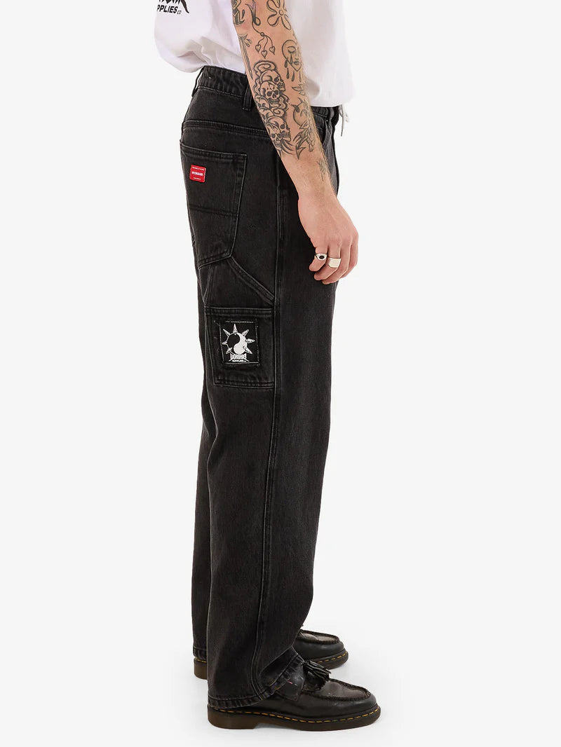Person wearing black cargo pants with a visible brand logo on a white background