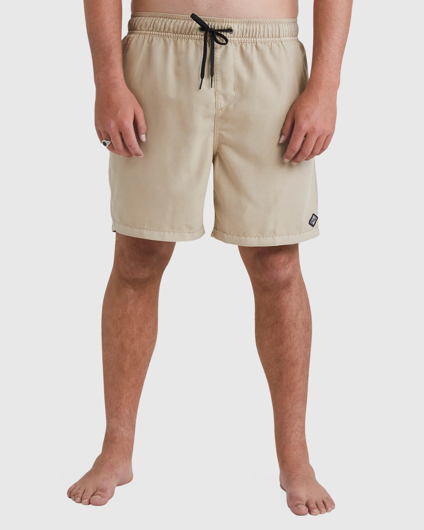 Beige shorts worn by a person on a white background