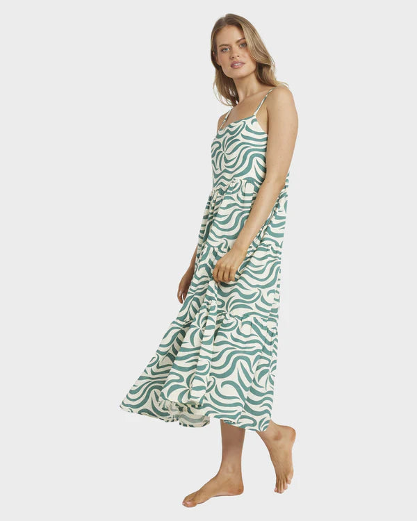 Woman wearing a green patterned dress on a white background