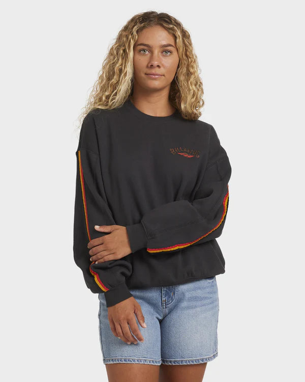 Woman wearing a black sweatshirt with colorful sleeves and denim shorts on a white background