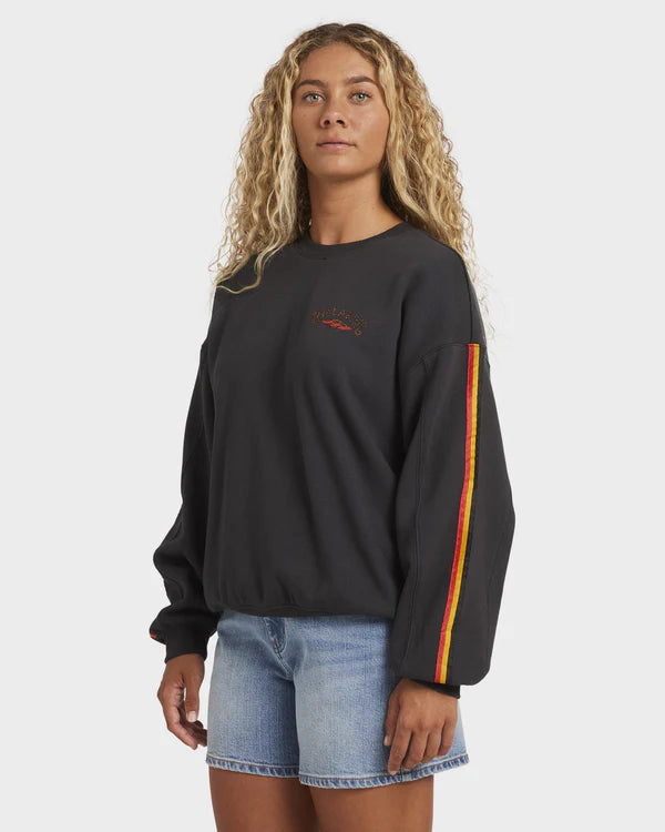 Person wearing a black sweatshirt with colorful stripes on a white background