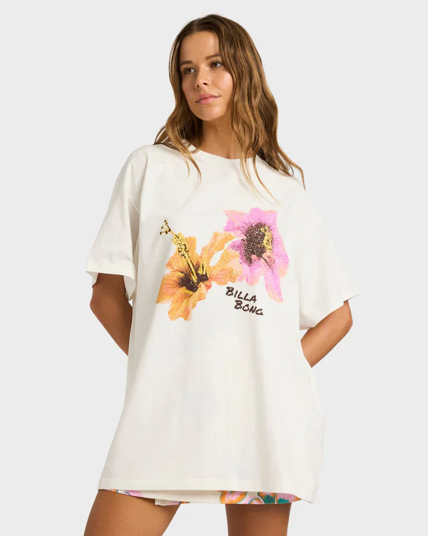 Woman wearing a white t-shirt with floral design and 'Billa Bong' text on a plain background