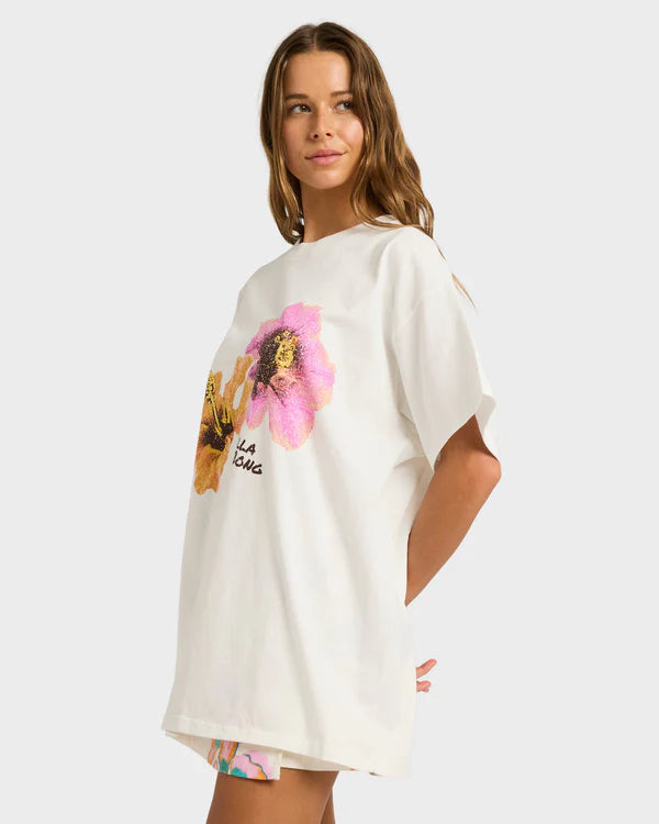 Woman wearing a white t-shirt with a graphic design on a plain background