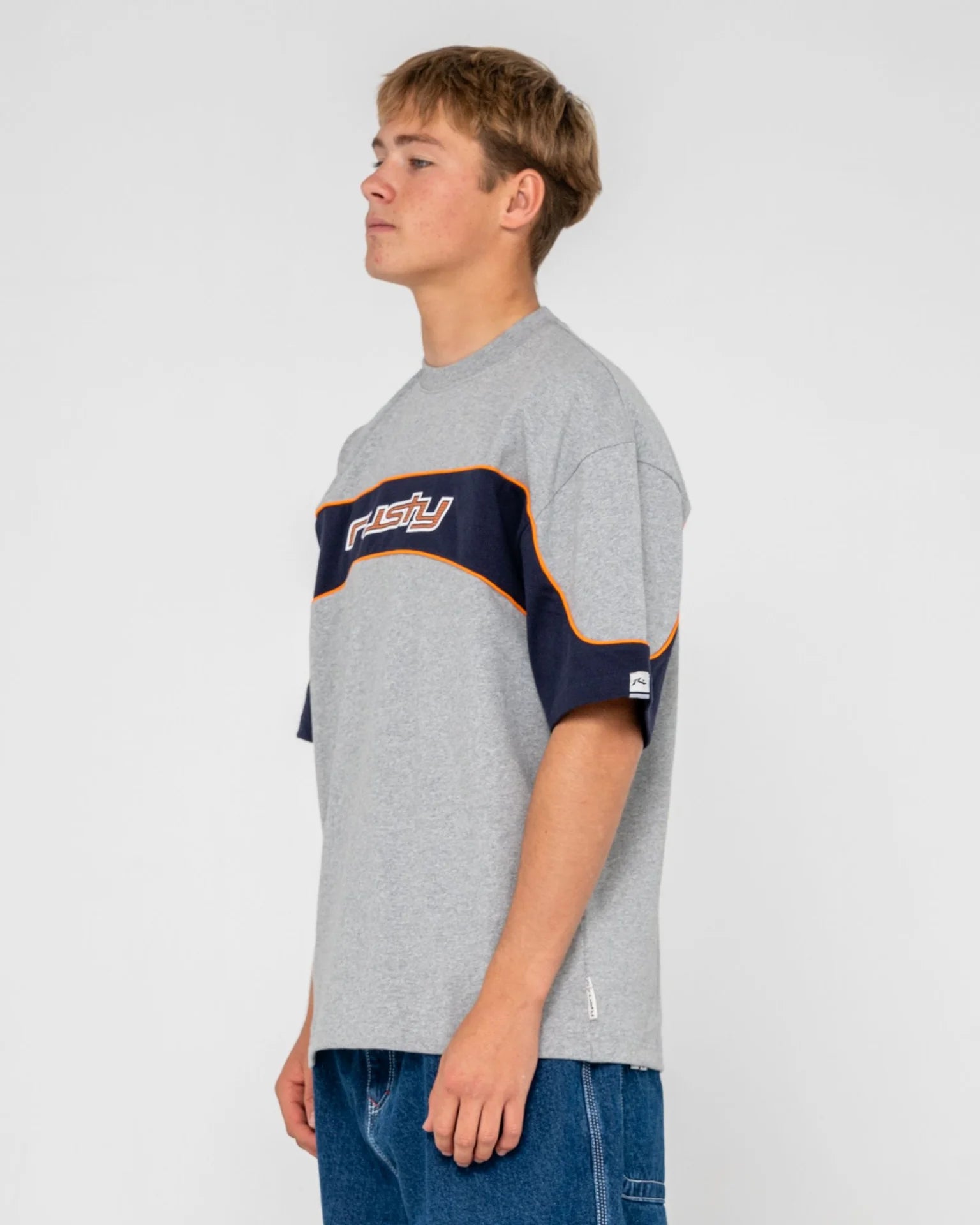 Person wearing a gray t-shirt with a logo on a white background