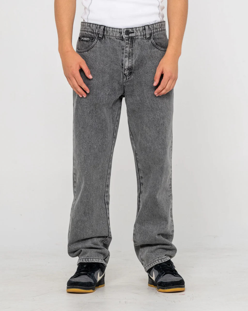 Person wearing gray jeans on a plain background