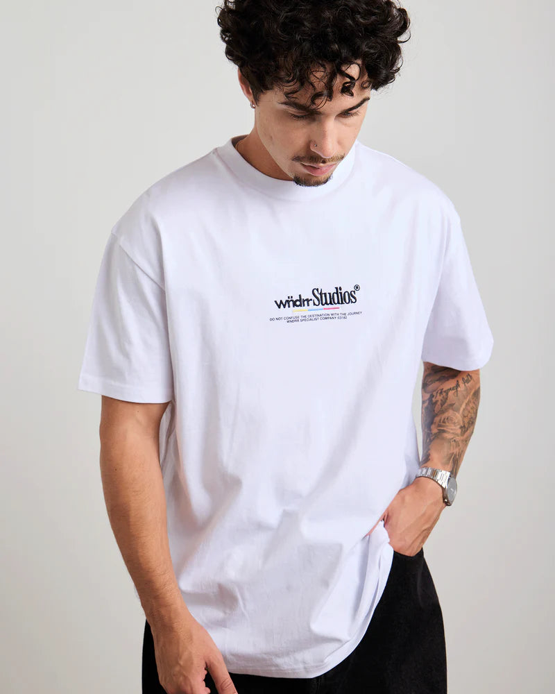 Person wearing a white t-shirt with 'Wndrr Studios' logo on a plain background